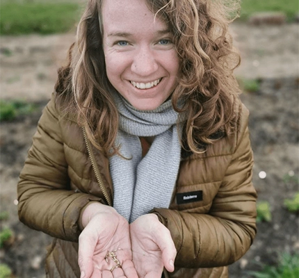 Adrienne from local grower Sweetpea Market Garden smiles while showing us her organic seeds